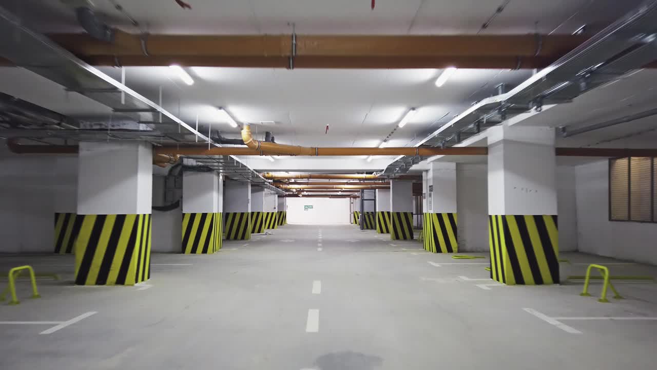 Pov驱动器在空的购物中心地下停车场或车库内部与混凝土条纹彩绘柱视频下载
