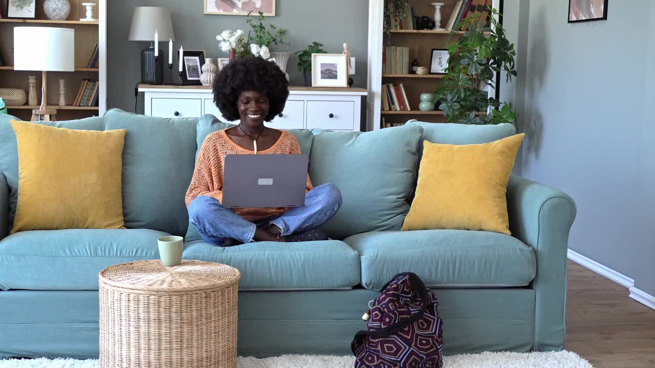 快乐的女人在家里使用笔记本电脑视频素材