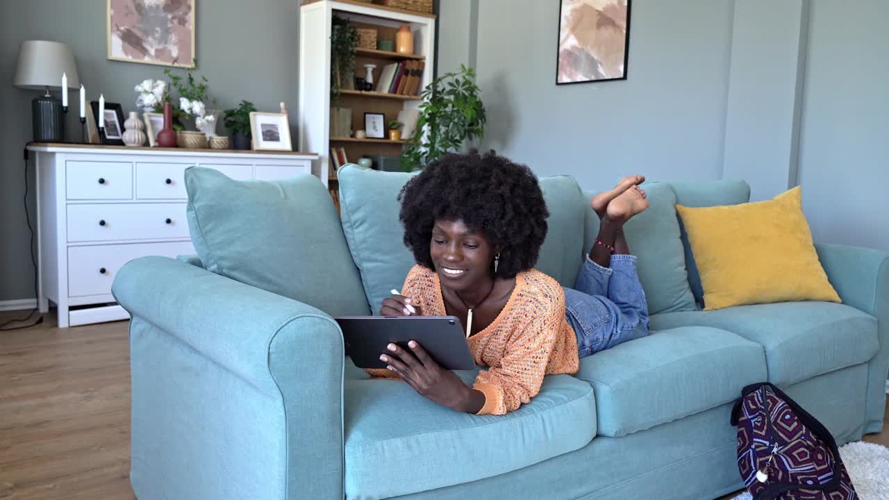 年轻快乐的女人在家玩她的平板电脑视频素材