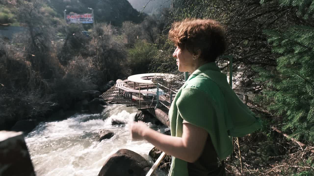 快乐的47岁女游客在春天的峡谷拍视频视频下载