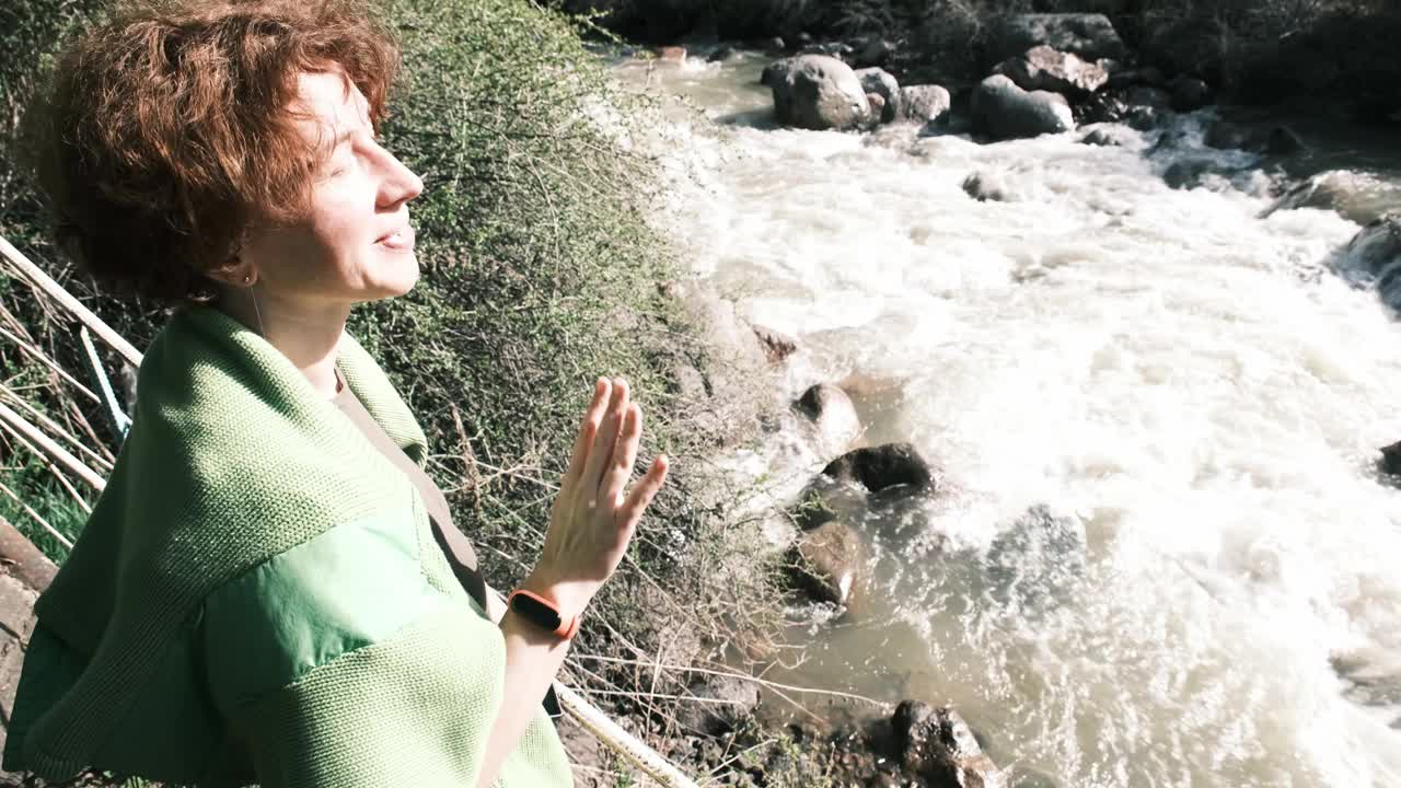 快乐的47岁女游客在春天的峡谷拍视频视频下载