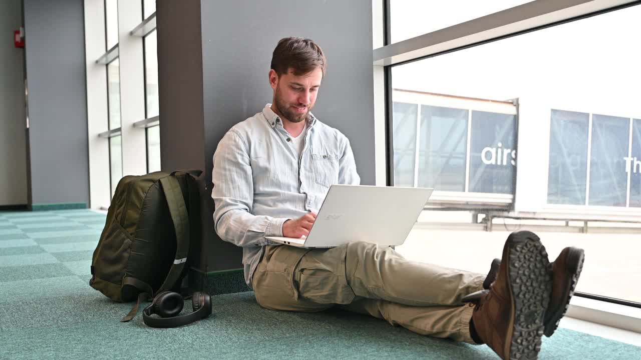 千禧一代在机场候机，用笔记本电脑和网络连接工作视频下载
