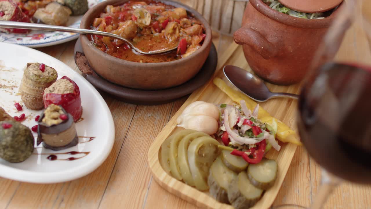 格鲁吉亚传统美食。素食的恰舒里配蘑菇，Phali——由坚果、各种蔬菜或香草和香料以及茄子卷制成的小吃，在陶罐里的lobio和腌制的蔬菜，还有一杯红酒。视频下载