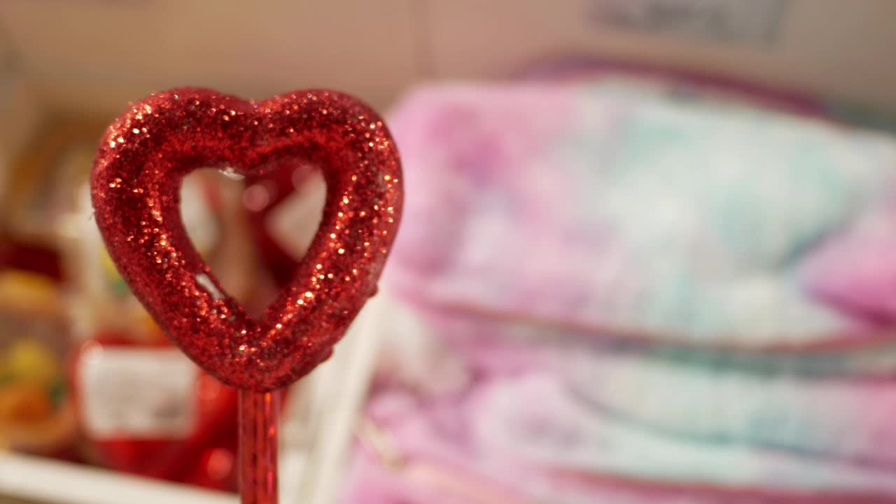 情人节。装饰的形式是一颗红色的心，在手中闪闪发光。情人节的浪漫礼物。节日装饰，情人节的装饰。爱的概念。视频下载