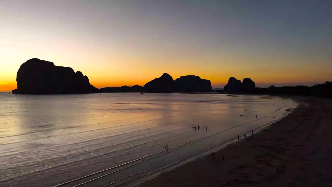 鸟瞰日落在泰国南部的庄省白孟海滩，海滩上的人们和游客视频下载