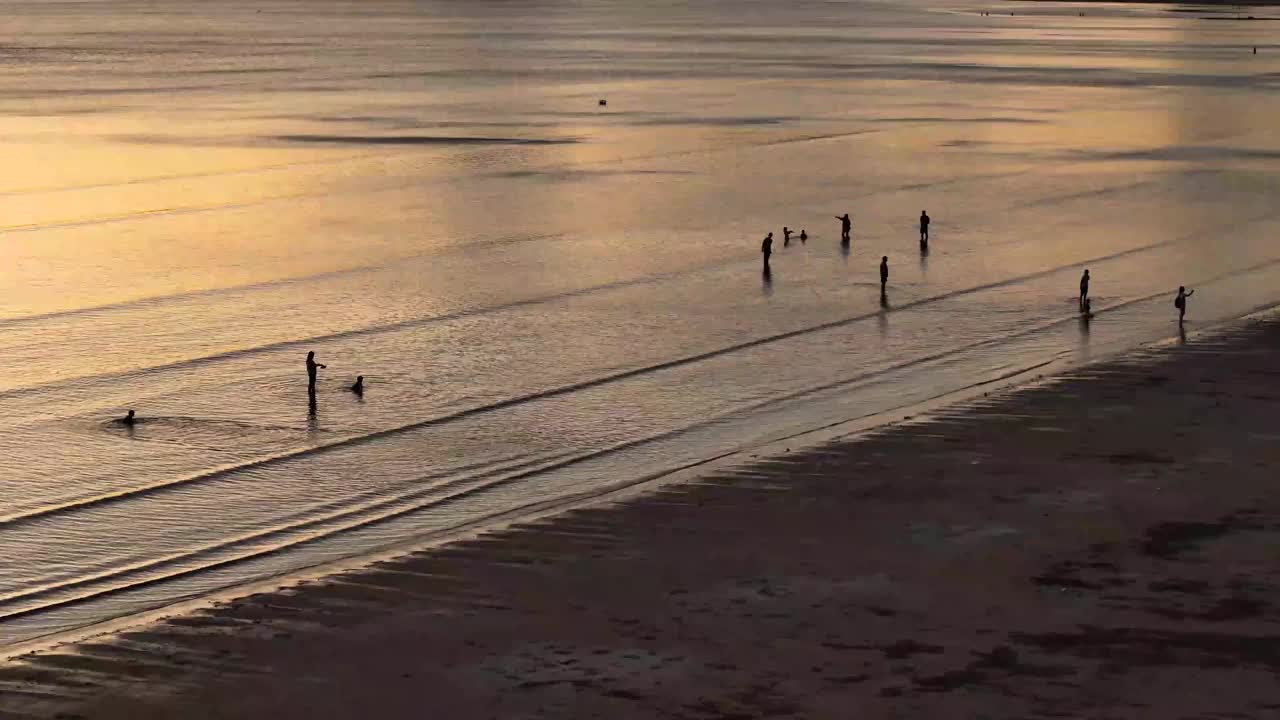 鸟瞰日落在泰国南部的庄省白孟海滩，海滩上的人们和游客视频下载