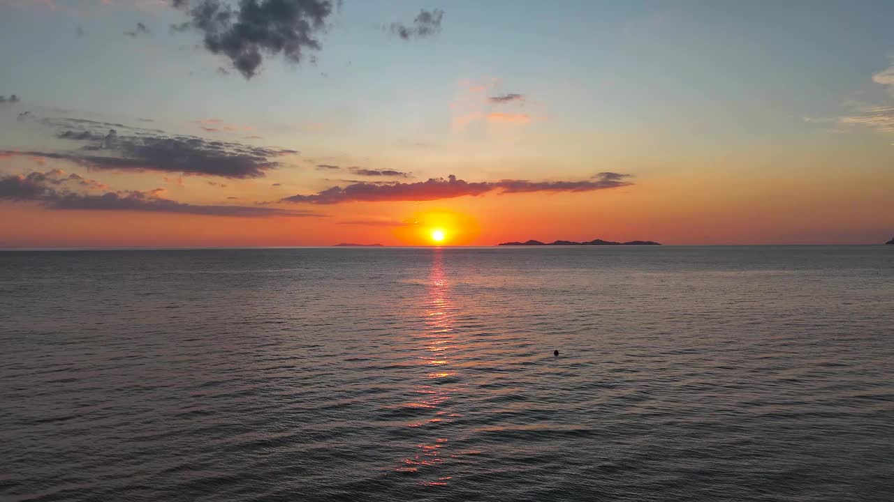 日落的天空在平静的海面上，从空中抽象的自然背景视频下载