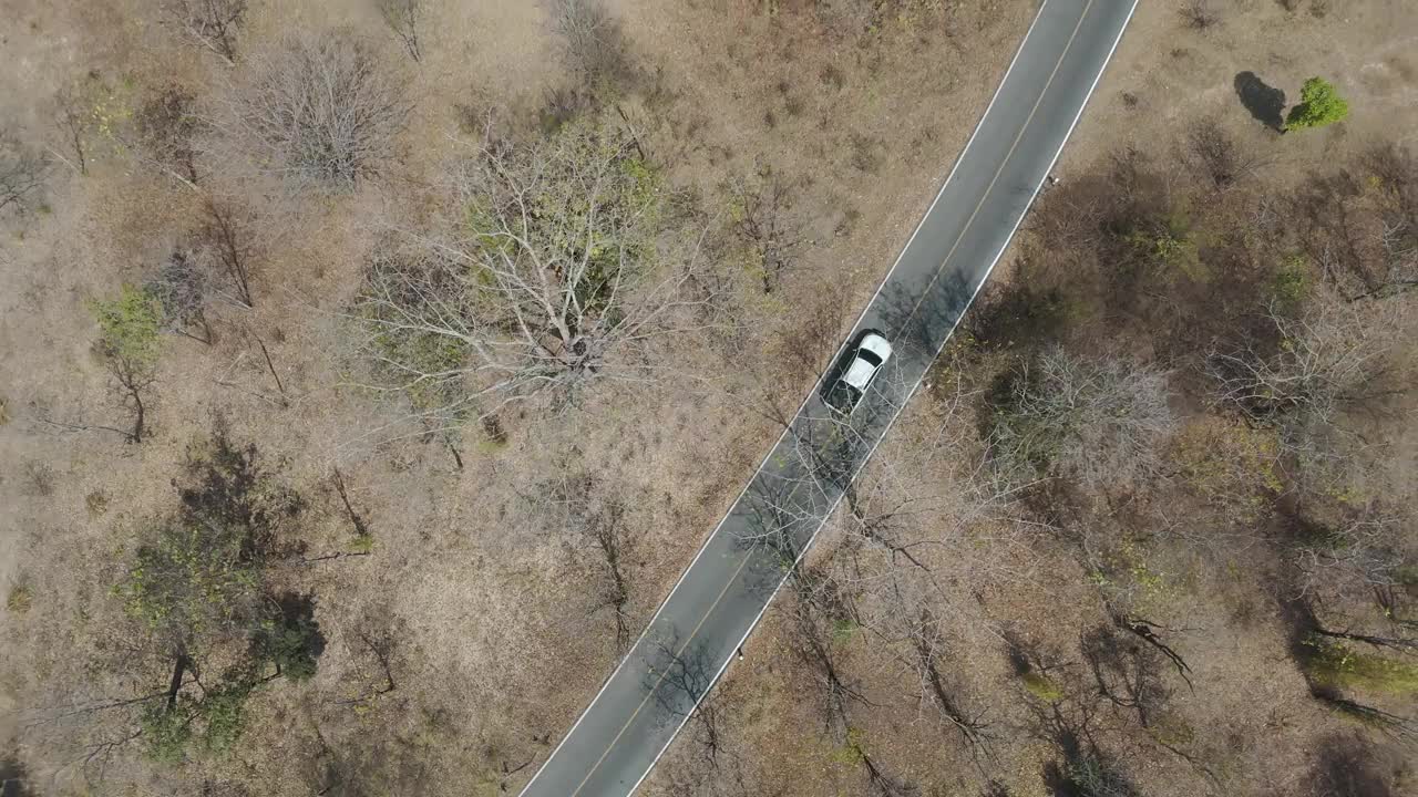 无人机拍摄鸟瞰风景，驾驶皮卡车在旱季偏僻的乡村道路上行驶视频下载