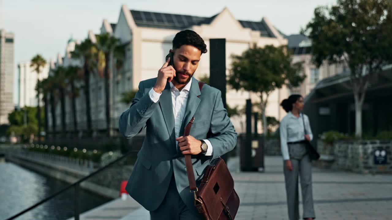 商人，带着幸福走在城市里，带着公事包打电话找好消息。男性，企业家和智能手机在迪拜的通信和商务对话。视频下载