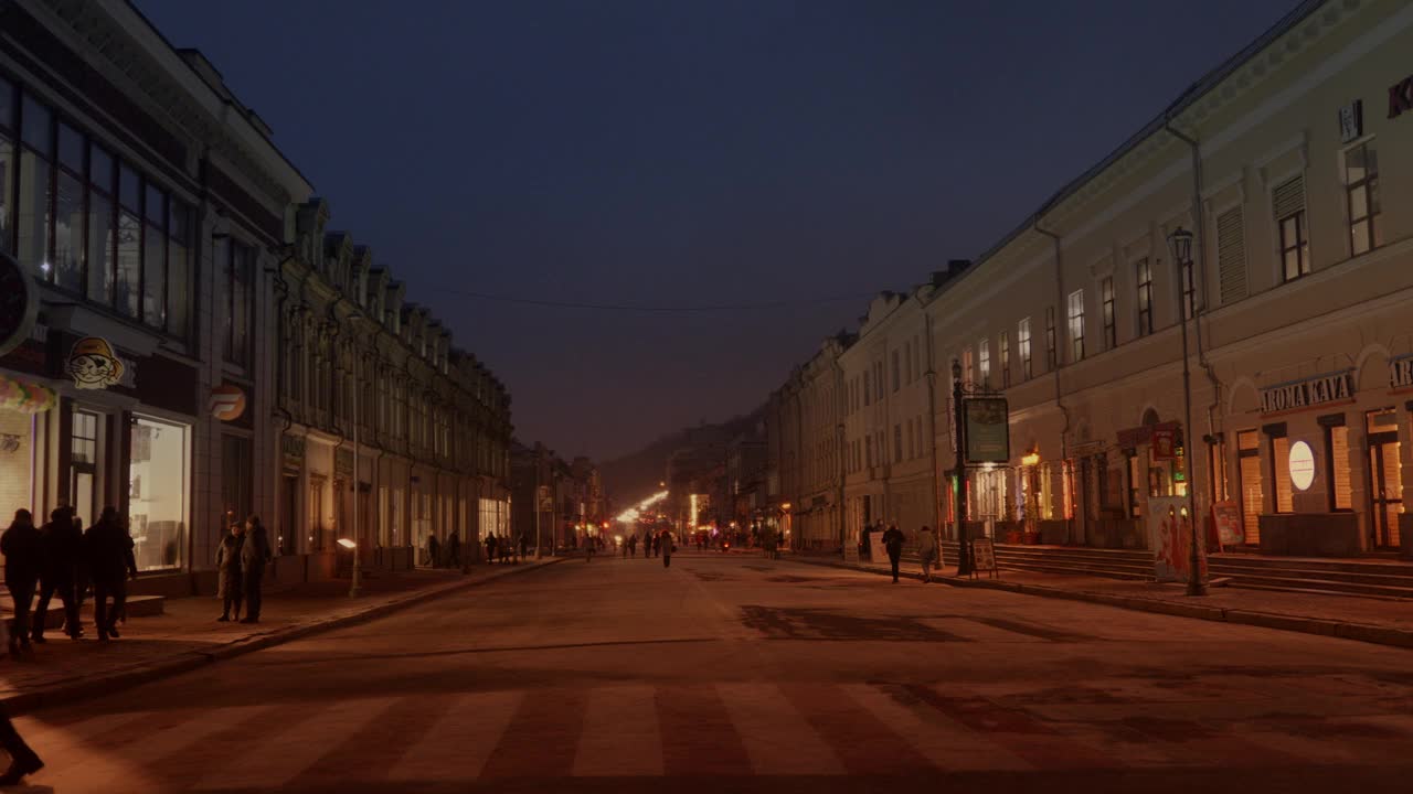 漫步在市中心的广场上，温暖明亮的夜晚视频下载