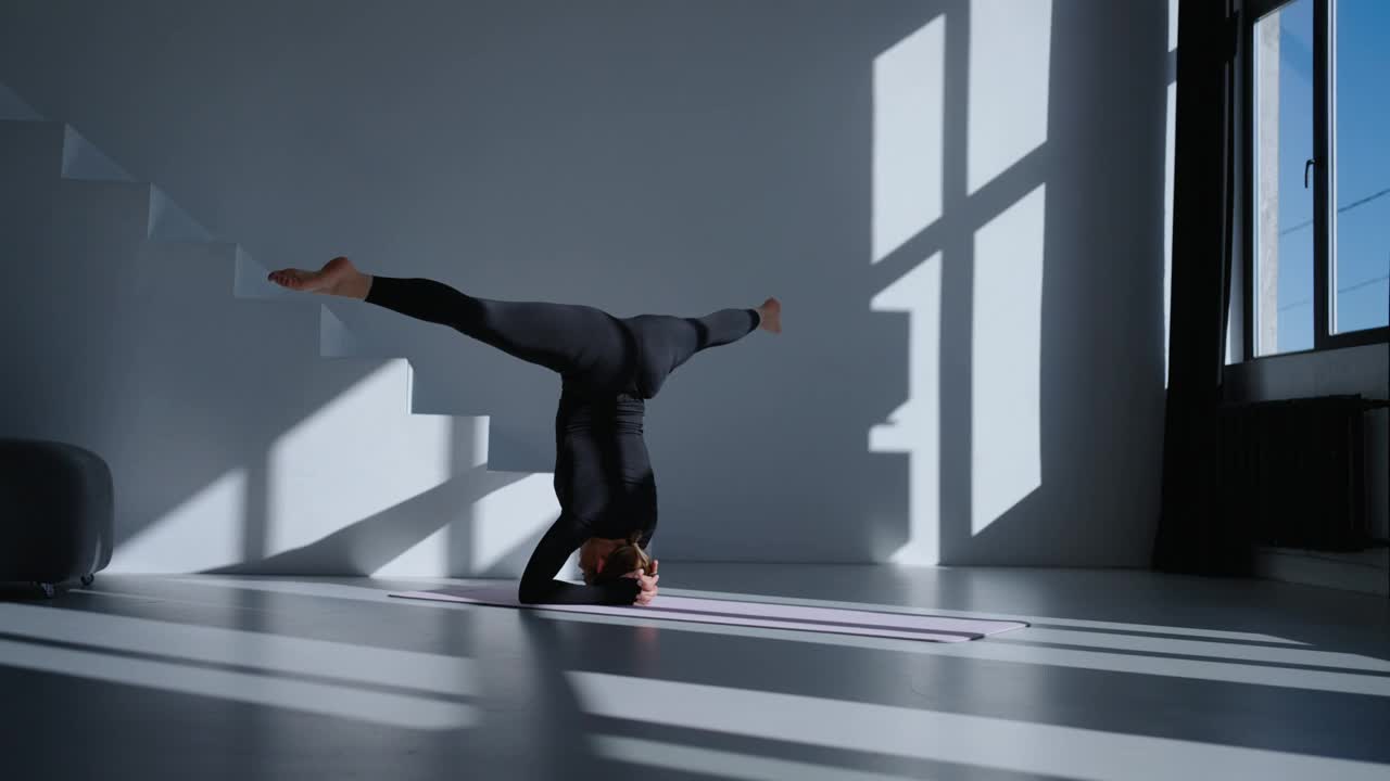 瑜伽锻炼，女运动员在健身工作室进行倒立和劈叉，平衡练习视频下载