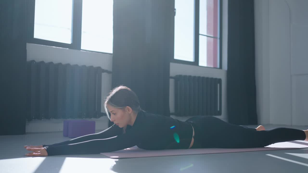 女士在健身房练瑜伽，女士躺在地板上，锻炼脊柱健康视频下载