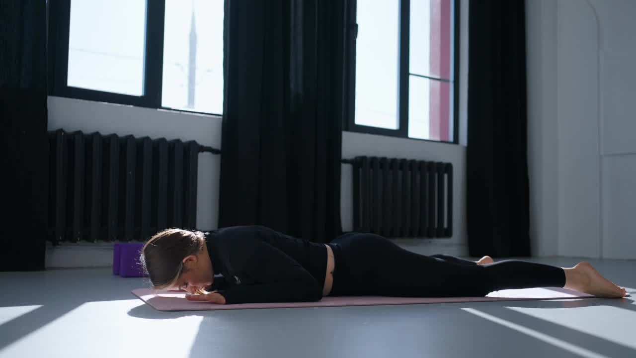 训练核心肌肉女性在健身室锻炼，躺在地板上，提升上半身视频下载