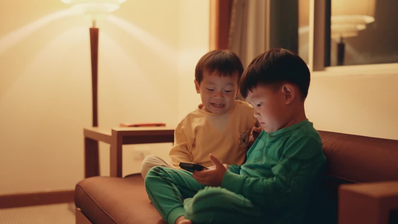 通过快乐的家庭游戏加强兄弟情谊:亚洲兄弟喜欢在线手机游戏，传播欢乐和快乐。视频下载