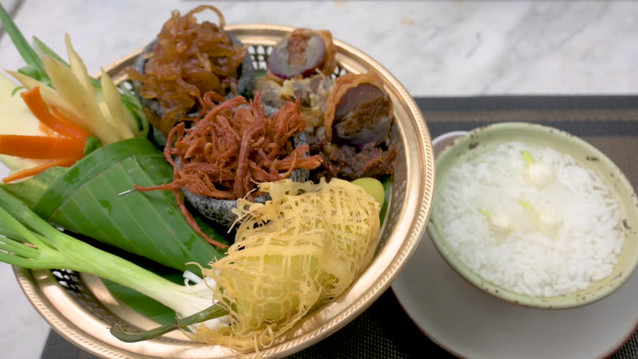 一套传统的泰国食物Khao Chae在黄铜碗和浅盘，泰国的侧视图视频下载