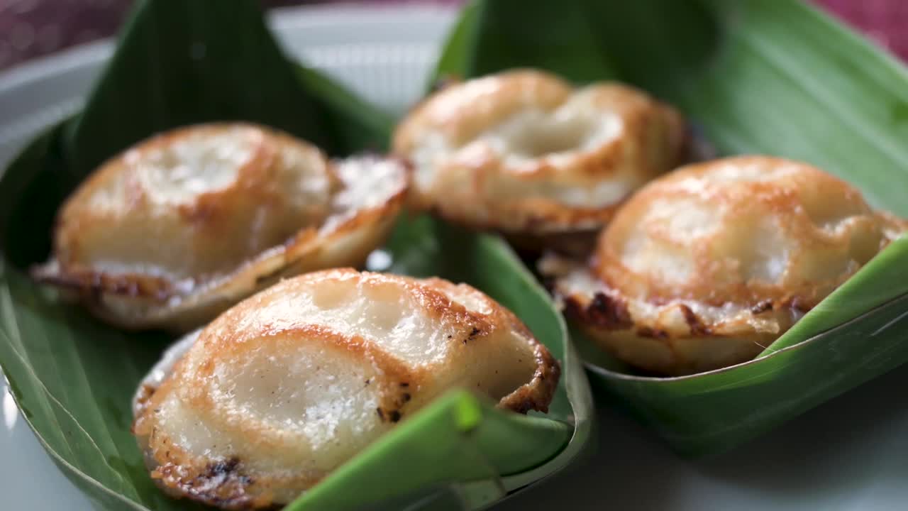 泰国煎椰子饼的特写，放在香蕉叶上。泰国视频下载
