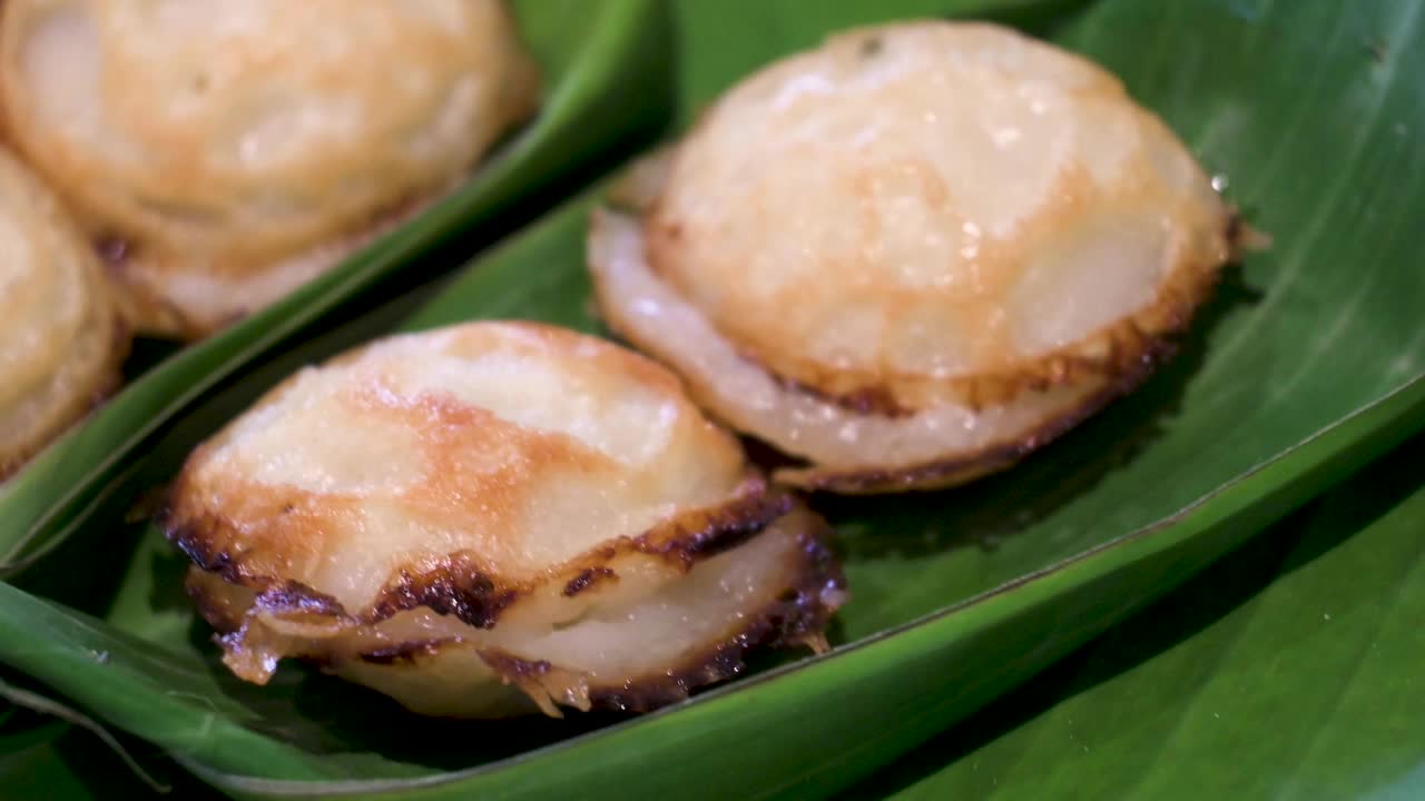 泰国煎椰子饼的特写，放在香蕉叶上。泰国视频下载