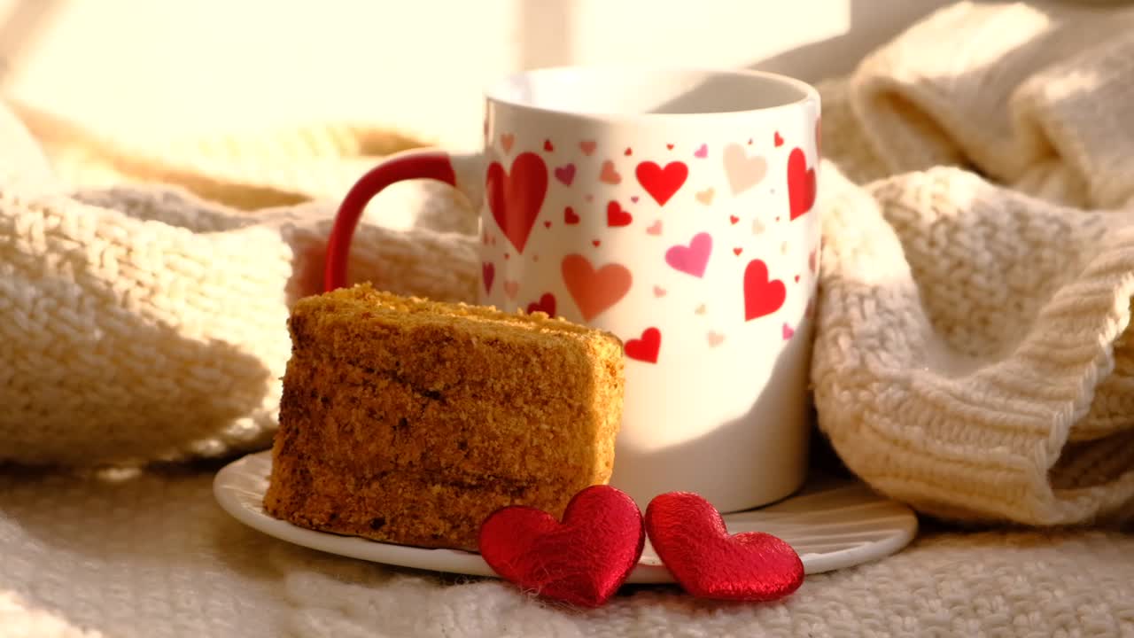 一杯咖啡和甜甜的蜂蜜胡萝卜蛋糕，浪漫大气的心情，两颗红红的心，编织温暖的格纹和阳光。情人节早餐视频下载