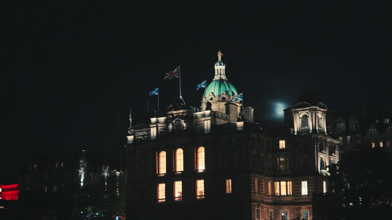 英国国旗和苏格兰国旗在夜晚的爱丁堡老城的圆顶上视频下载
