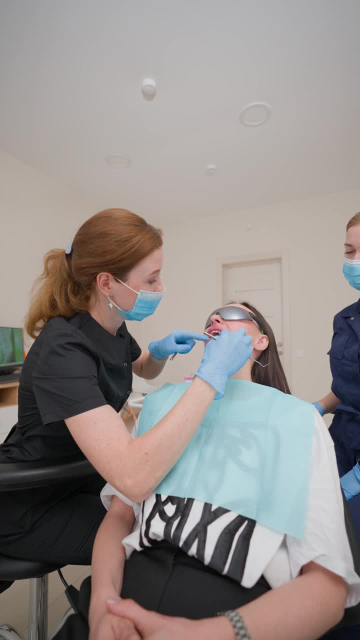一名妇女在牙科诊所接受牙医的牙齿治疗视频下载