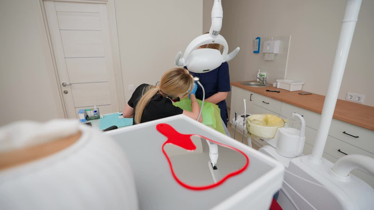 牙医在诊所检查女病人，为患病的牙齿开处方视频下载