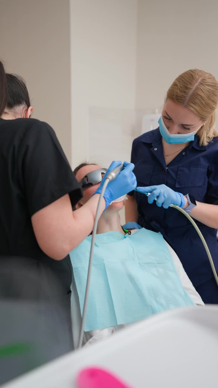 女牙医与助理在牙科诊所为病人拔牙视频下载