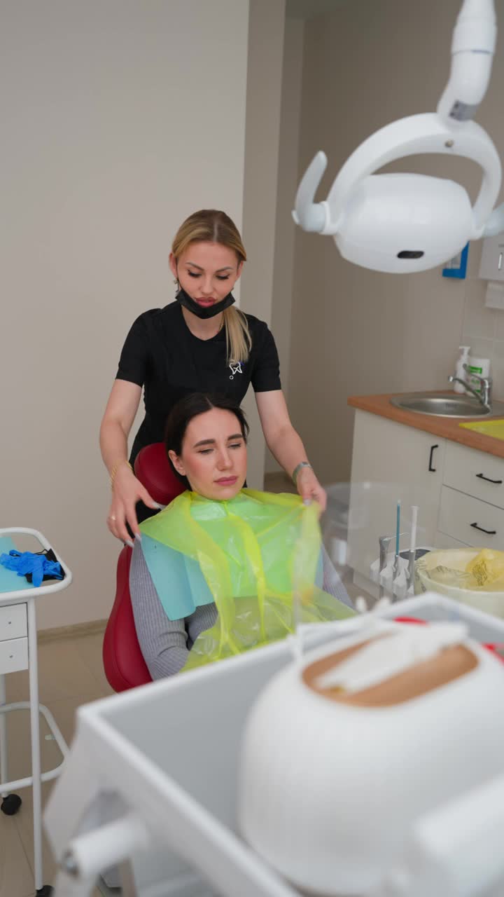 金发女牙医在牙科诊所为病人准备牙齿治疗视频下载