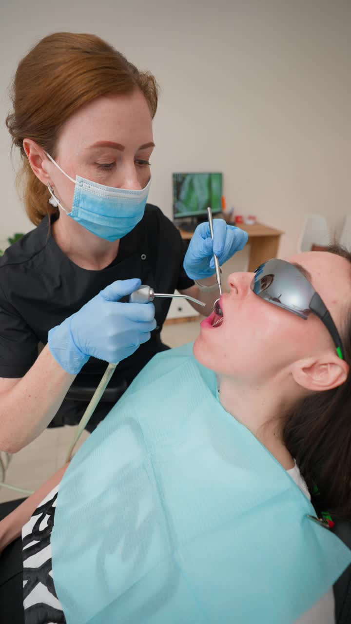 女牙医及助理在牙科诊所检查女病人口腔视频下载