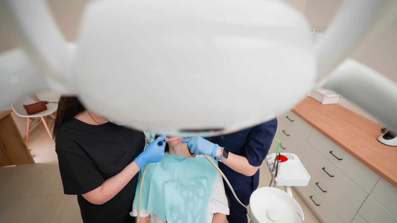 女牙医与助理在牙科诊所为病人拔牙视频下载