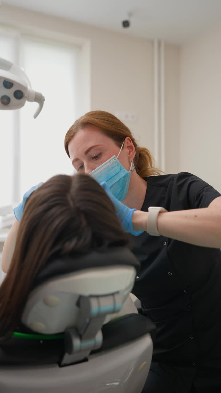牙科医生用现代设备检查年轻的成年女病人视频下载