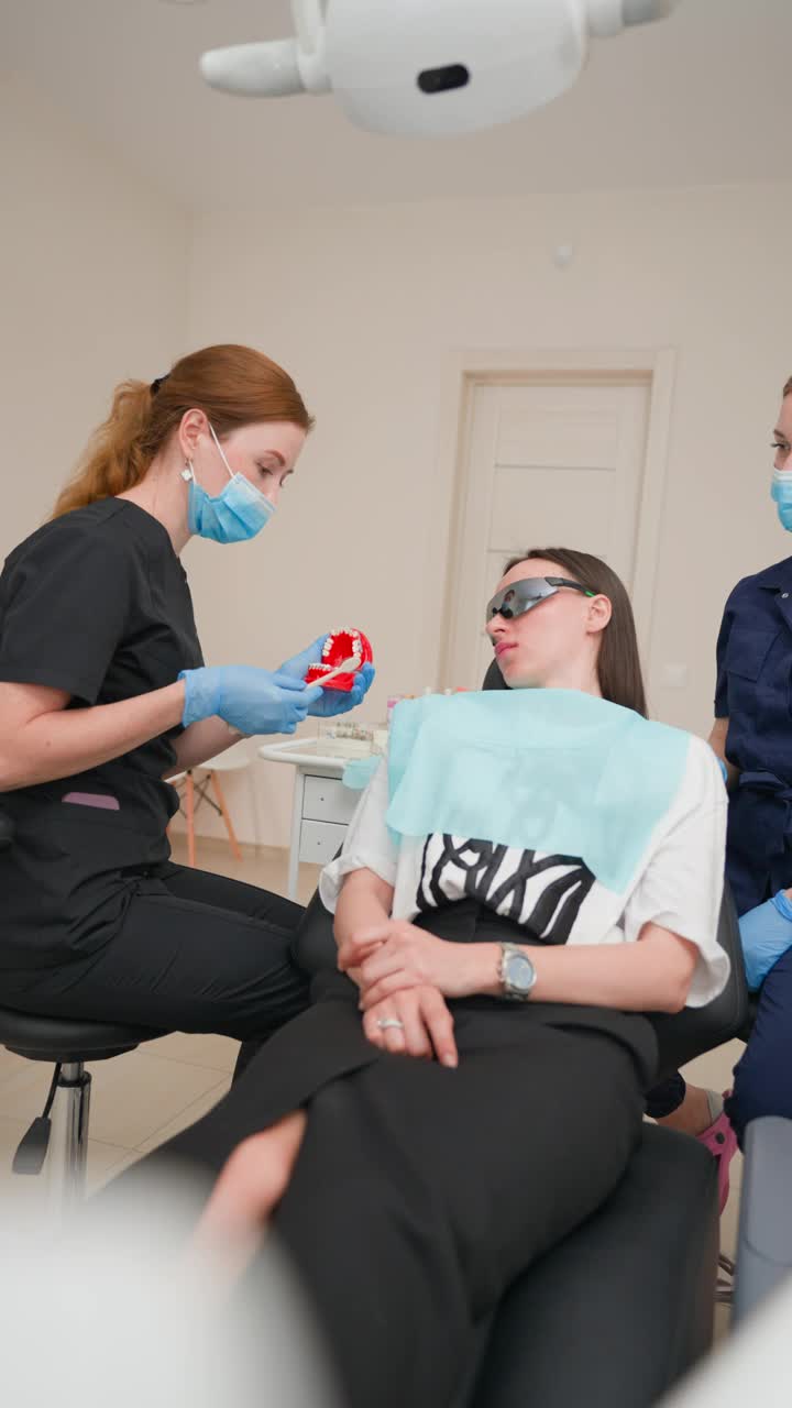 女牙医在牙科诊所教病人如何正确刷牙视频下载