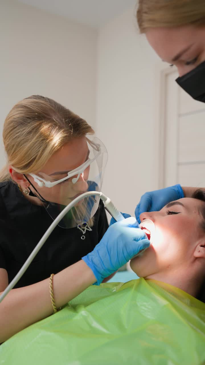 女牙医在牙科诊所为病人清洁牙齿视频下载