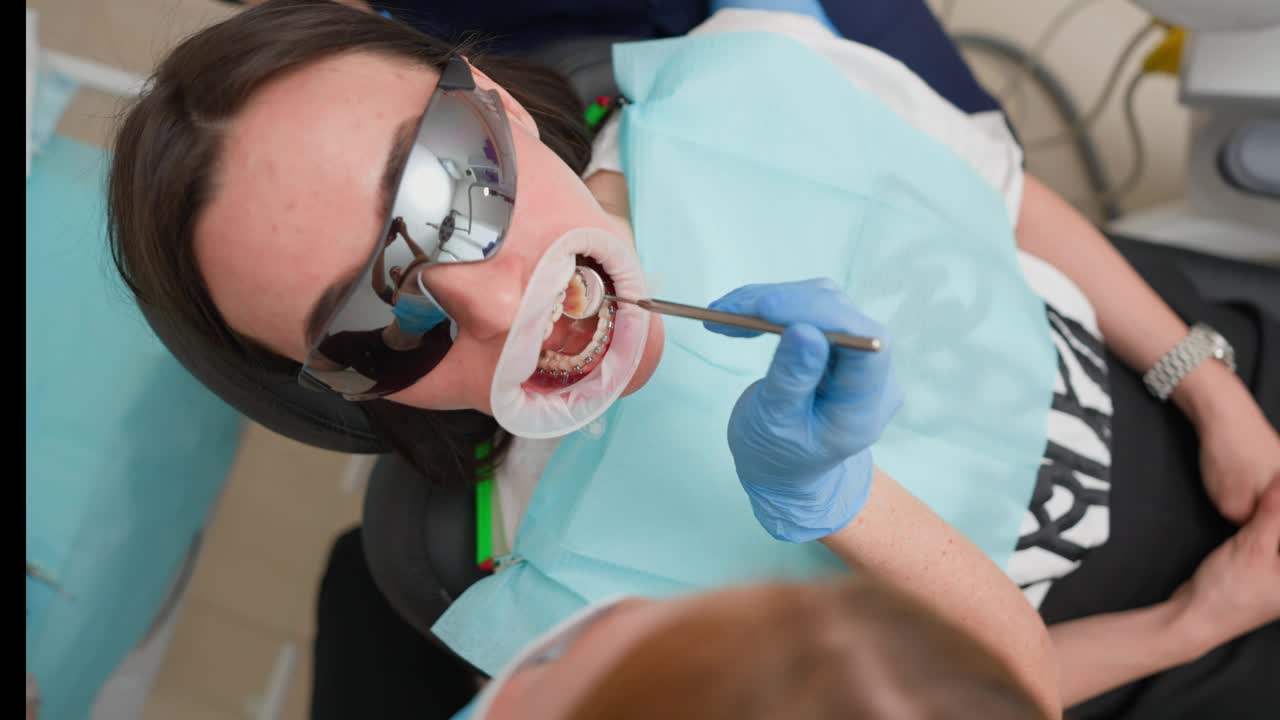 牙医在诊所检查女病人，为患病的牙齿开处方视频下载