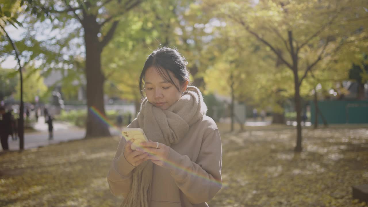 秋天，一名年轻女子在城市公园欣赏令人叹为观止的景色。视频下载