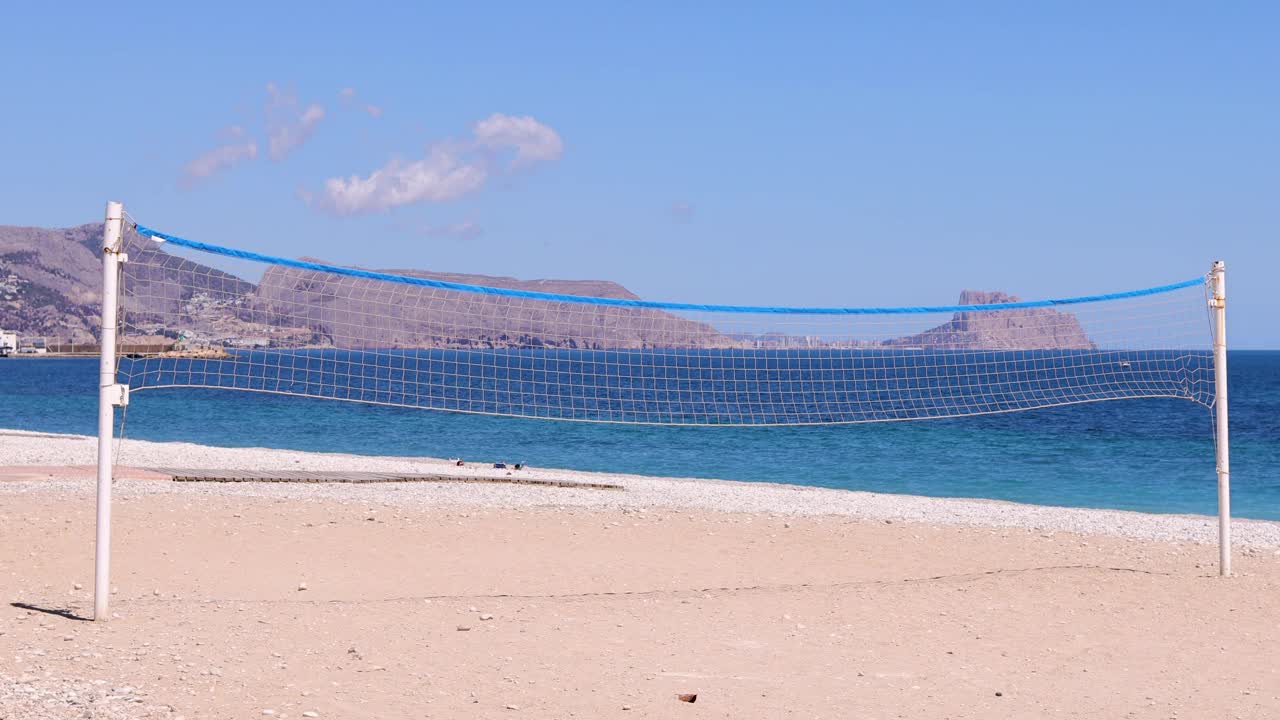 在西班牙阿利坎特的阿尔比尔，阿尔特亚，美丽的海滩的镜头显示了沙滩前的沙滩沙滩沙滩上的排球网，海滩被称为普拉亚de Cap Blanch视频下载