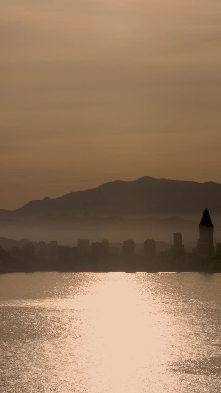 西班牙贝尼多姆镇夕阳西下的人像镜头，背景是山脉和酒店的剪影视频下载