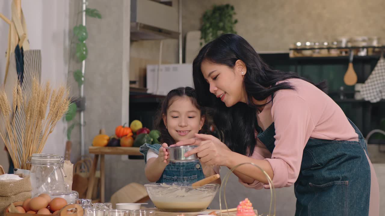 一个女人和一个小女孩在厨房里做蛋糕视频下载