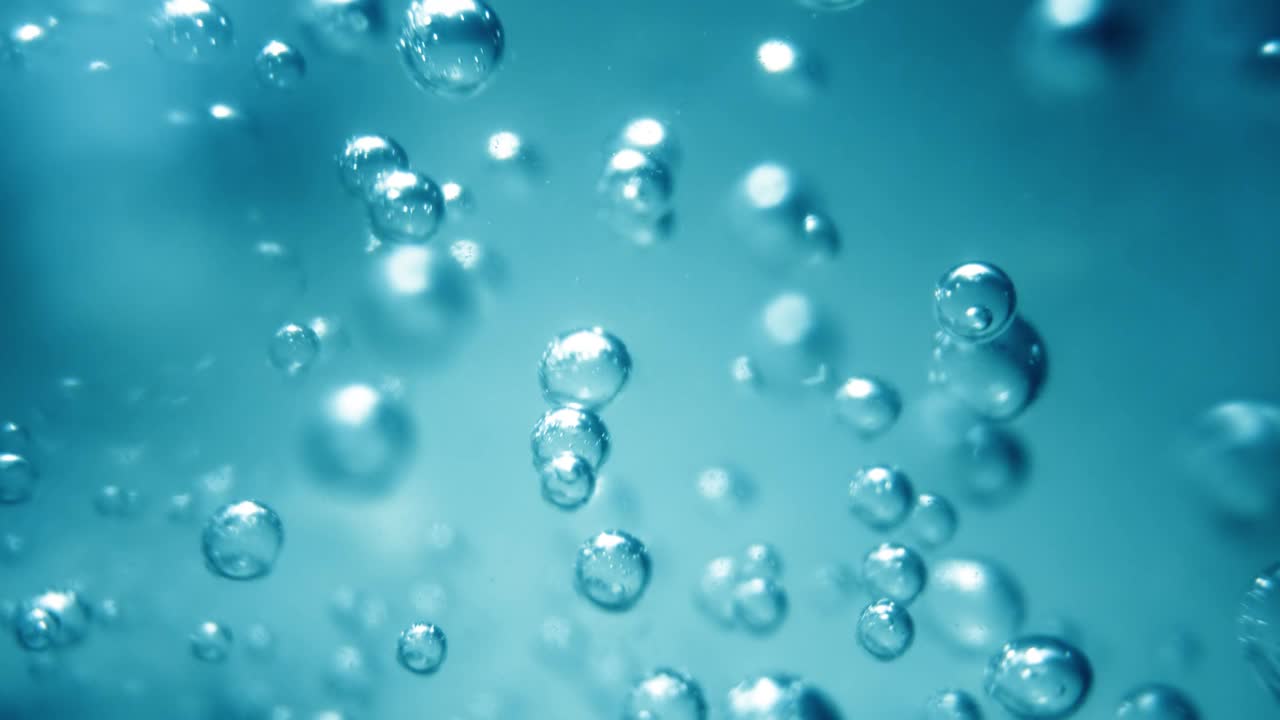 蓝色水中的许多水泡近距离观察，用气泡慢动作抽象水波。视频下载