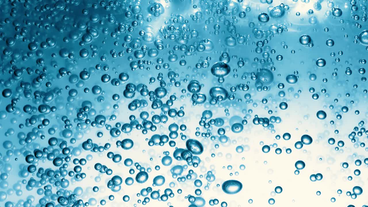 蓝色水中的许多水泡近距离观察，用气泡慢动作抽象水波。视频下载