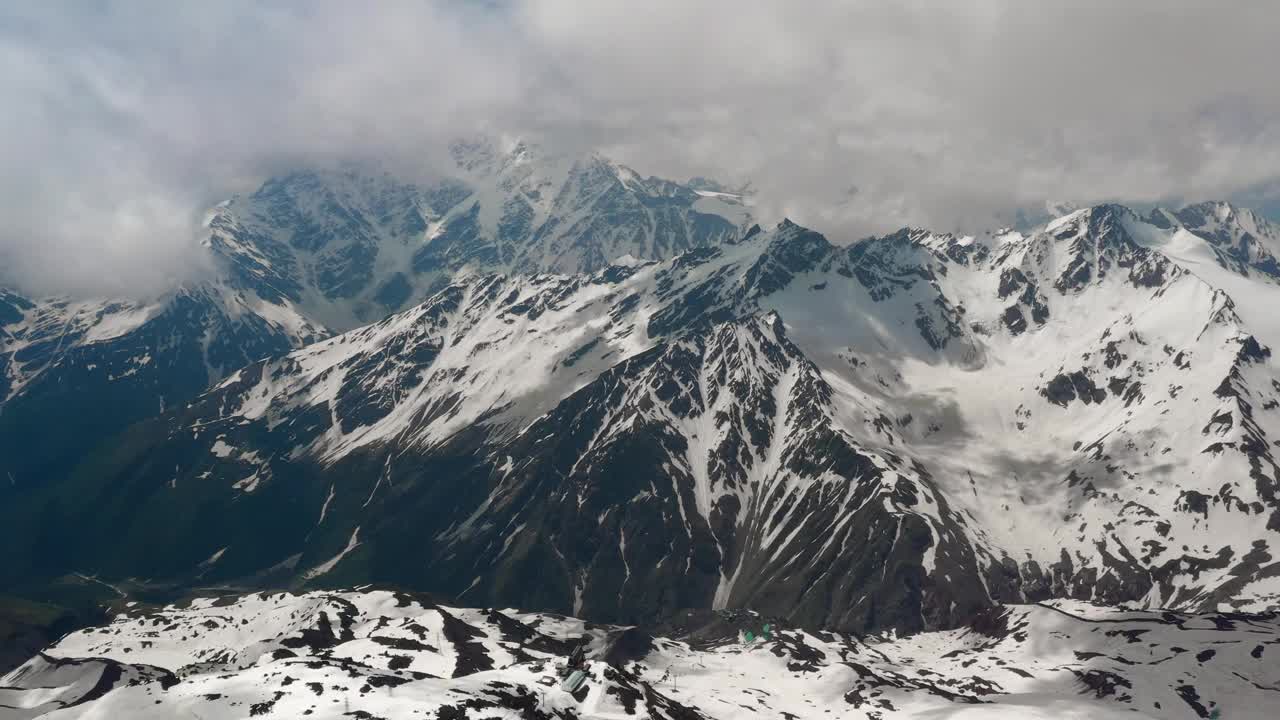空中飞行穿过山云，飞越美丽的雪峰和冰川。视频下载