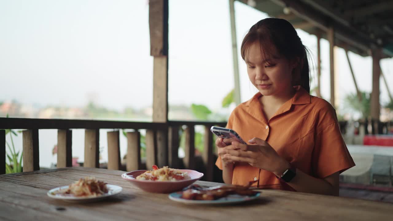 一个十几岁的女孩在当地餐馆给食物拍照。视频下载