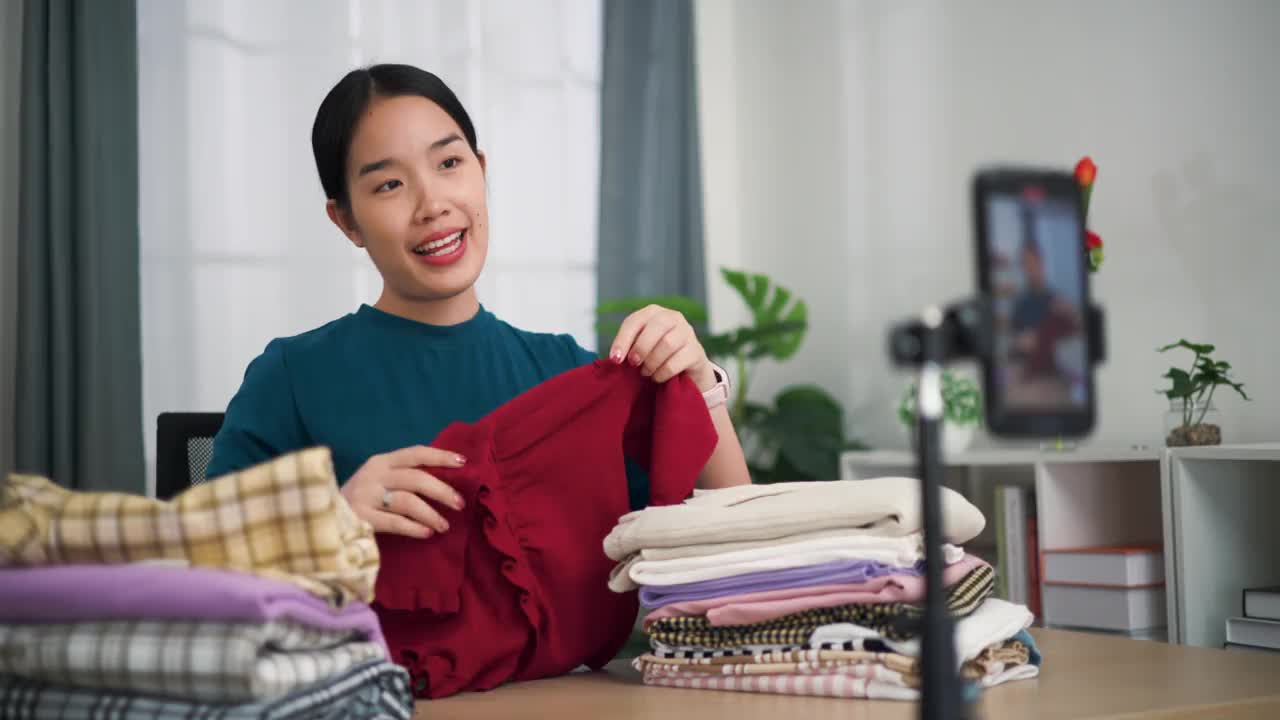 卖衣服的年轻女企业主用手机直播向顾客展示最新的时装系列视频下载