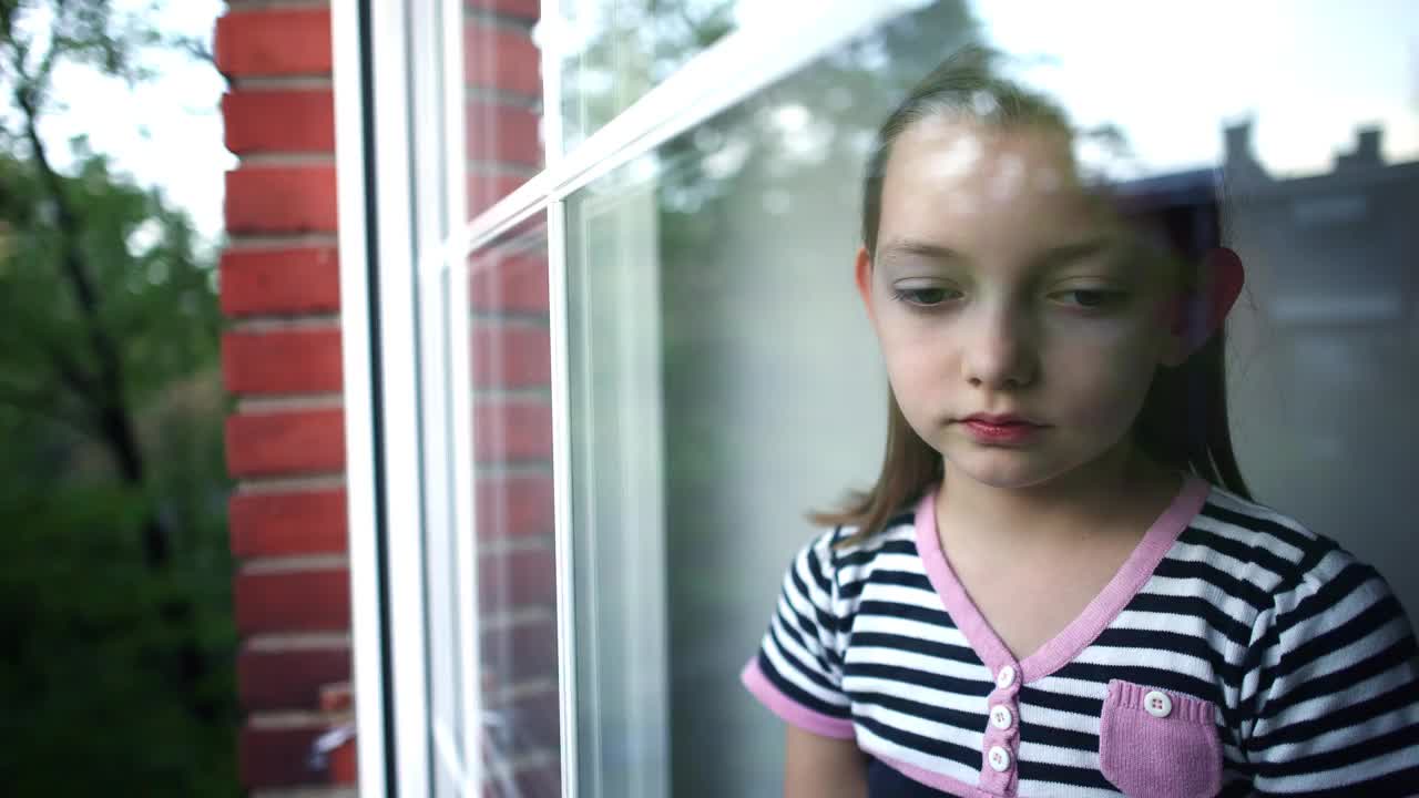 悲伤的高加索女孩，揉着她的眼睛，从她的房间望向窗外视频下载