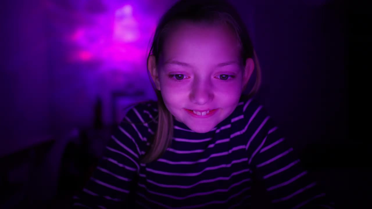一个白人女孩，在一个led照明的房间里玩电子游戏视频下载