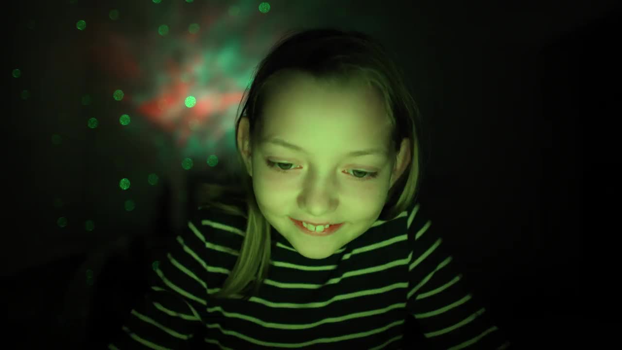 一个白人女孩的肖像，在一个led照明的房间里玩电子游戏视频下载