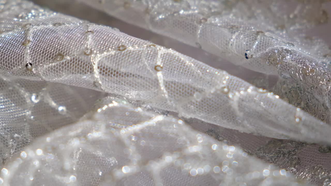 婚纱蕾丝和带有珠子和珍珠的织物特写，柔和的光线，视频下载
