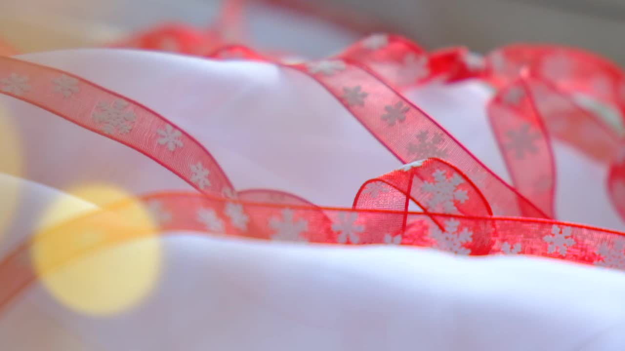 圣诞节气氛浓厚。节日的装饰，红丝带上有雪花的图案。雪白的背景。圣诞快乐，新年快乐视频下载