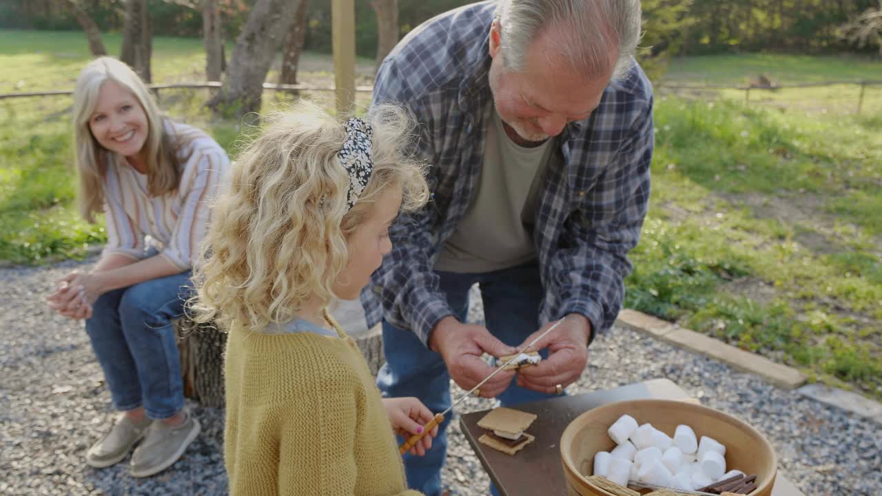 小女孩在与家人露营时学习如何制造烟雾视频下载