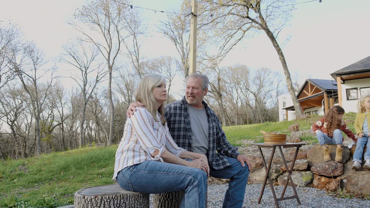 一对老年夫妇坐在家门口的火坑旁视频下载