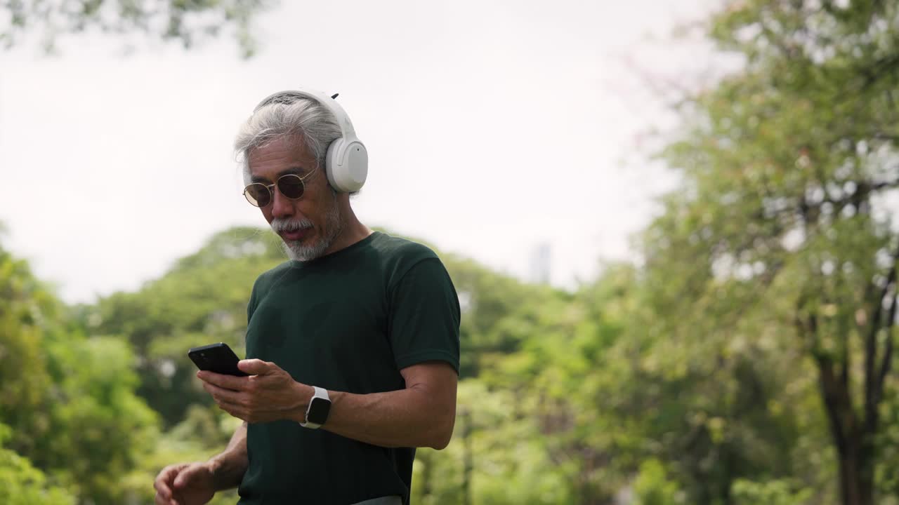 一位老人在花园里用智能手机，视频下载